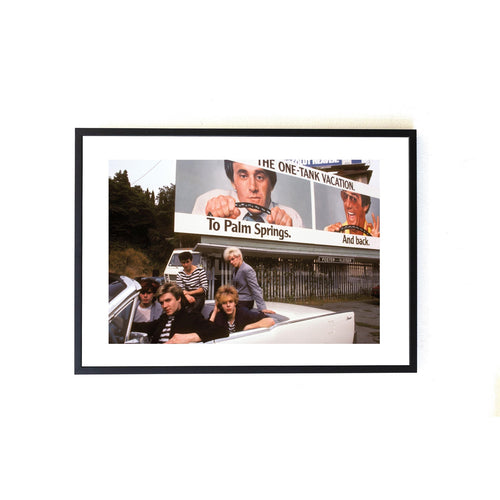 A color photo of Duran Duran members posing in a white car on Sunset Blvd, taken by Brad Elterman.