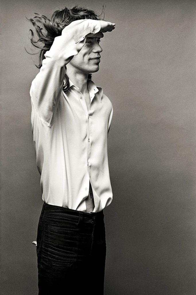 Black and white photograph of Mick Jagger saluting. Shot by Photographer Norman Seeff in Los Angeles in 1972.