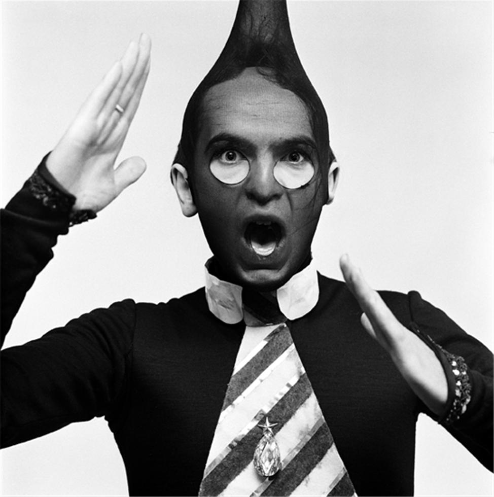 A black and white photograph of Peter gabriel wearing a stocking on his head. The image is embossed with a signature stamp and is part of a limited edition collection.