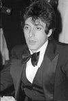 A black and white photograph of Al Pacino at the Tony Awards in 1977, wearing a suit and bow tie.