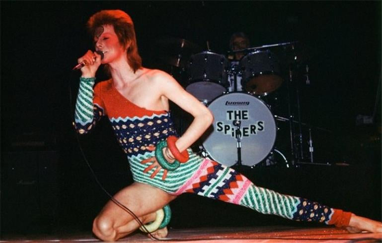 A limited edition fine art photograph of David Bowie, known as Ziggy Stardust, singing into a microphone. The image is embossed with Mick Rock's signature stamp.