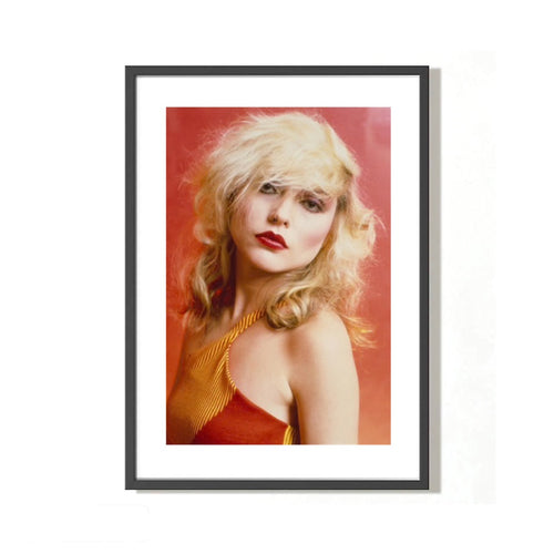 A fine art photograph of Debbie Harry, Blondie, 1978, by Mick Rock, with a signature stamp and a yellow abstract background.