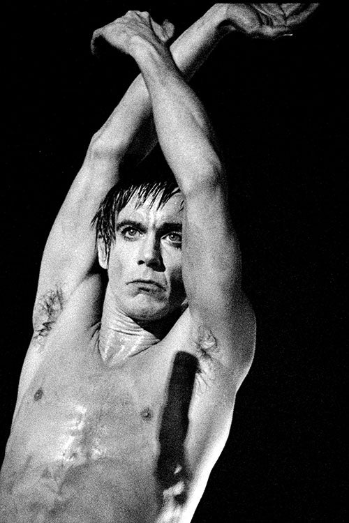 Iggy Pop performing passionately on stage at Manchester Apollo, 1977, captured by photographer Kevin Cummins.