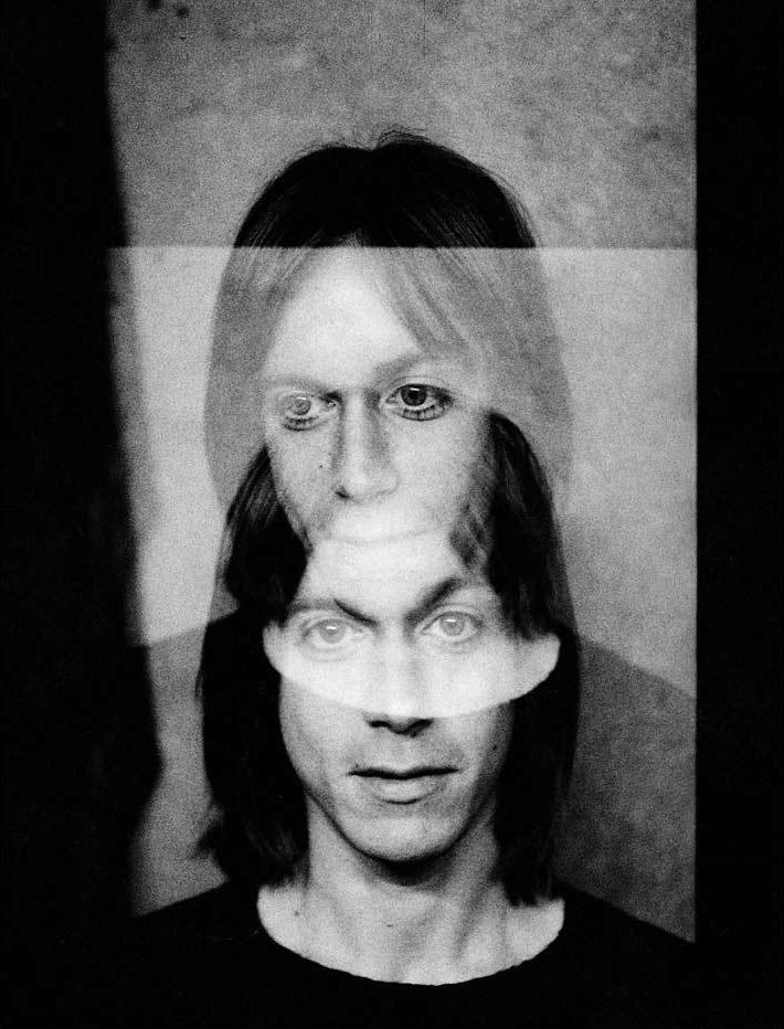 A limited edition fine art, black and white, double exposure photograph of Iggy Pop. The image is embossed with Mick Rock's signature stamp.