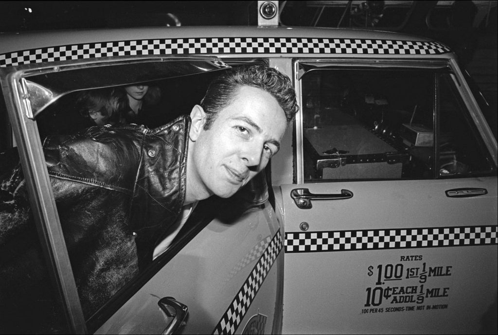 a fine art photo of Joe Strummer of The Clash in a nyc taxi with his head out the window. 