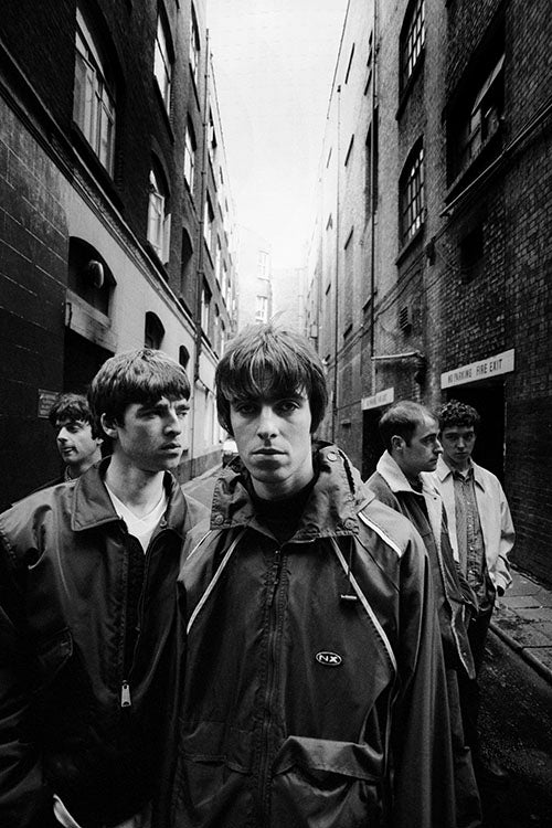 Oasis, London, 1994; iconic black and white photo of the rock band in an urban alleyway.