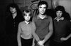 Black and white photograph of Talking Heads band members in a casual setting, 1977.
