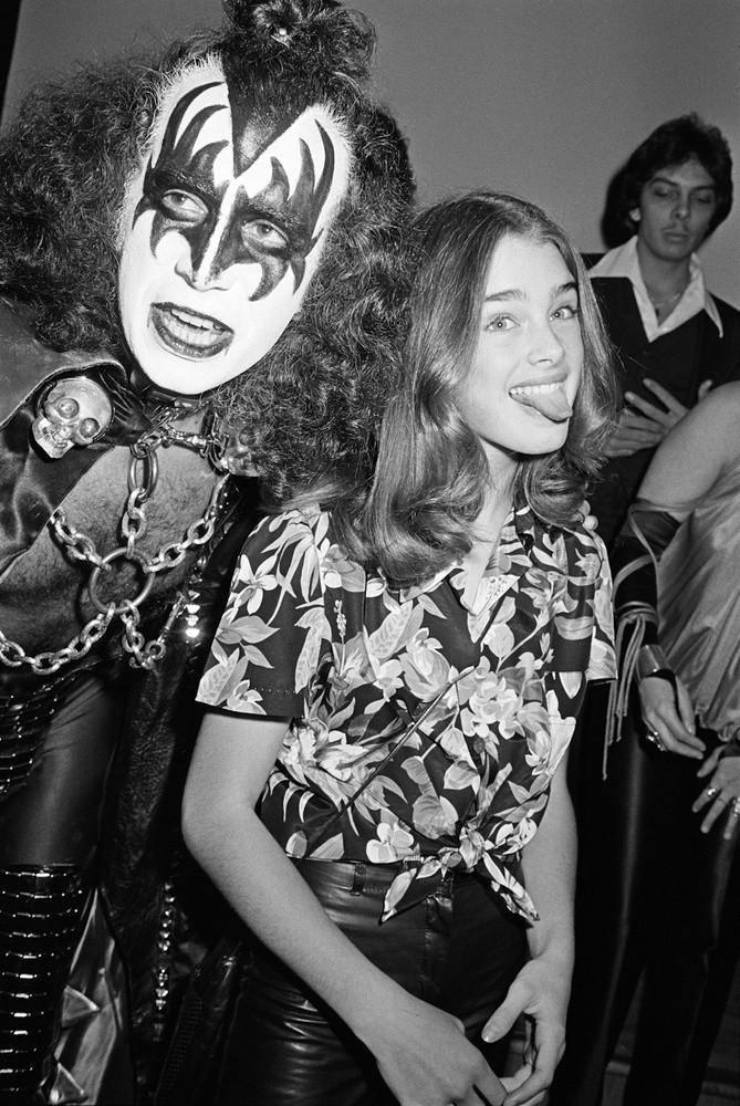 photo of Gene Simmons of Kiss with Brooke Shields, actress, young, shot in 1978 by photographer Brad Elterman, Black and white photo, tongue out, singer, performer, rock star, sunset blvd, Collectors Edition, Limited edition photograph, Rock n roll photography, Fine art photography, wall decor,  home decor, luxury, decor, interior design, home, art, music, pictures, photography, art gallery La Maison Rebelle, Los Angeles, rock photography., makeup, at party. 
